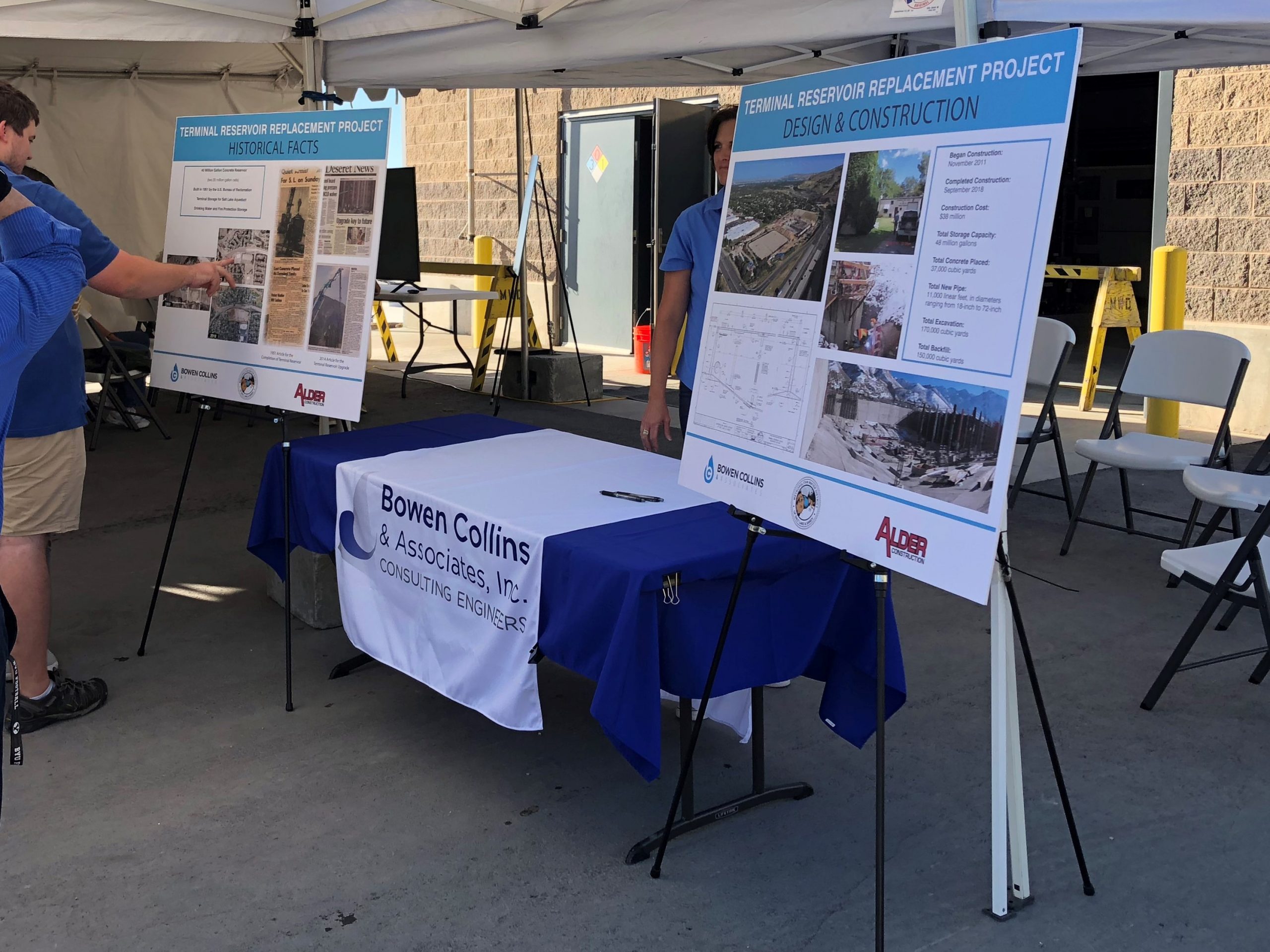 Bowen Collins booth set up under tent with posters providing information about the Terminal Reservoir design and construction.