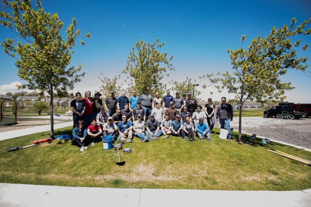 Group photo of Bowen Collins employees smiling on grass.